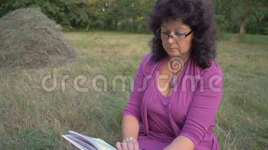 中镜头，戴眼镜的老年妇女，翻开书页，体贴入微地阅读，坐在清算中
